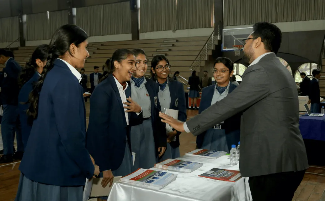 A busy exhibition hall with students visiting institute booths